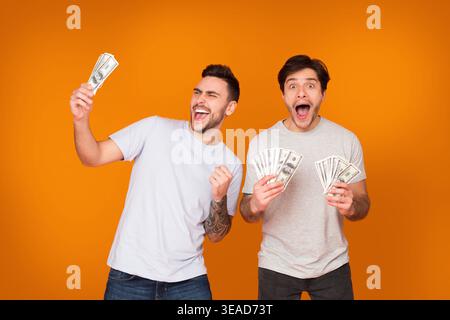 Satisfied men holding bunch of money banknotes Stock Photo