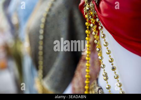 Close up view shows traditional Thai clothing featuring beautiful golden jewelry over bright red fabric creating an elegant mannequin display full of Stock Photo