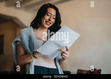Smiling student reading notes in a classroom preparing for a presentation Stock Photo