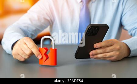 Cracked padlock and man with mobile phone, symbolizing cyber security breach, data protection risks, hacking, digital security, online privacy, and te Stock Photo