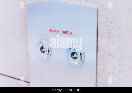 Fireman's switch on a brushed metal control panel, providing essential fire safety and emergency control in buildings Stock Photo