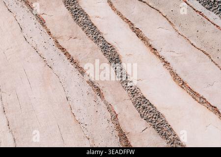 Abstract pattern showing diagonal lines with textured rock and rough sand, creating a dynamic surface background Stock Photo