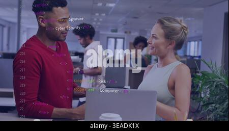 Discussing coworkers in red longsleeve and sleeveless top reviewing laptop code overlay at office Stock Photo
