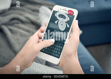 Close-up of woman holding smartphone with AI assistant hologram showing error message. Concept of chatbot failure, artificial intelligence problem, mo Stock Photo