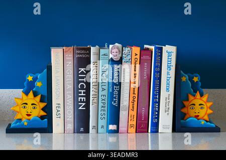 row of cookery books showing spines with bookends on kitchen top - cookbooks cook books Stock Photo