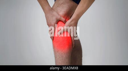 Man massaging his inflamed knee, close up Stock Photo