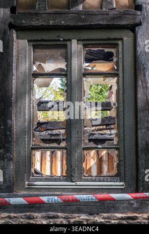 Close up of the window of the ruins of a house burned in a fire accident or arson Stock Photo