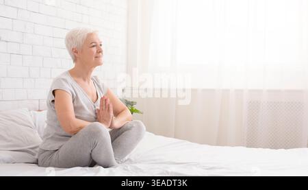 Young caucasian woman practicing yoga in bed Stock Photo