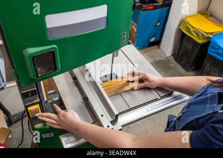 Woman Operating Woodworking Machine in Carpentry Studio Stock Photo