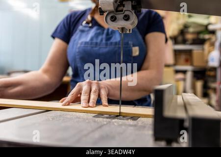 Woman Operating Woodworking Machine in Carpentry Studio Stock Photo
