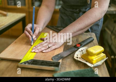 Measuring Wooden Element with Ruler in Workshop Stock Photo