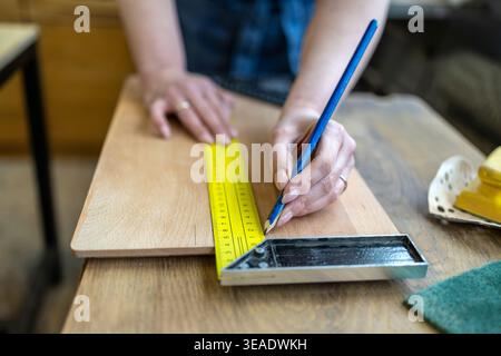 Measuring Wooden Element with Ruler in Workshop Stock Photo