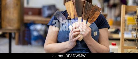 Woman Holding Wood Stain Color Samples in Carpentry Workshop Stock Photo