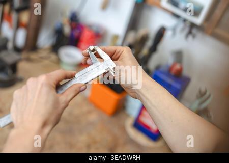 Measuring Small Component with Caliper in Workshop Stock Photo