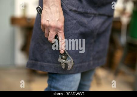 Carpenter Holding Wrench Tool in Workshop Stock Photo