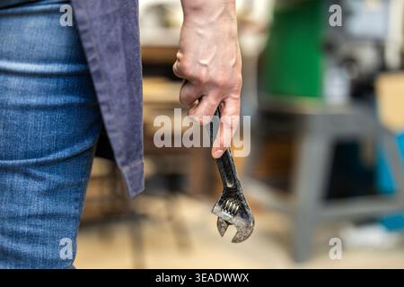 Carpenter Holding Wrench Tool in Workshop Stock Photo
