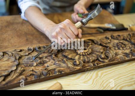 Restoring Ornate Wooden Panel with Carving Tools Stock Photo
