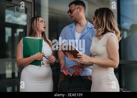 Three young professionals having a business discussion outside a modern office building Stock Photo