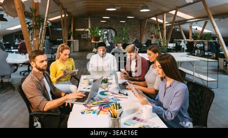 Concentrated designers working in office, using laptops Stock Photo