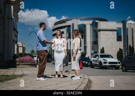 Three professionals having a casual business meeting and conversation on a sunny city street Stock Photo