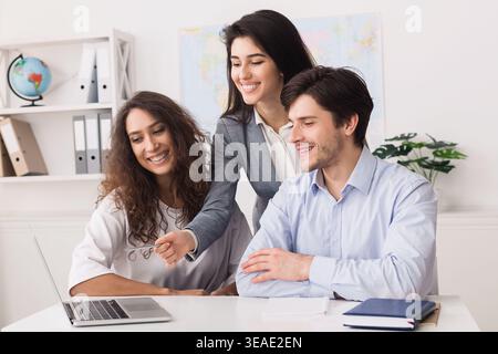 Group of Young People Collaborating on a Project With a Laptop in a Modern Office Setting Stock Photo