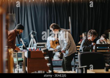 Students playing foosball and board games in a casual recreation room at school or community center Stock Photo