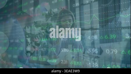 Thinking Asian woman wearing light blouse and listening in office, with laptop market charts Stock Photo