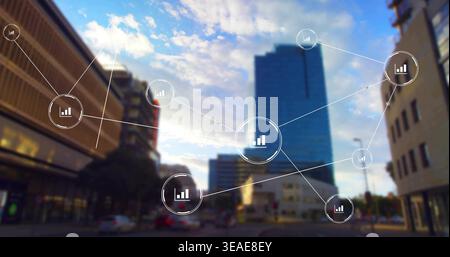 Displaying central data node overlay showing bar icon over city intersection, glass tower and cars Stock Photo