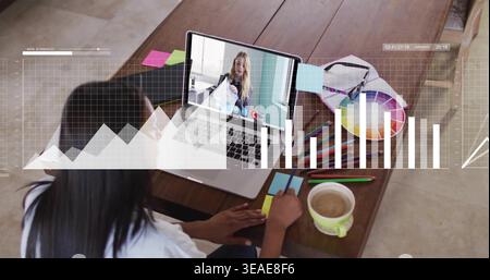 Writing woman wearing light top, working at wooden table with laptop call, sticky notes, copy space Stock Photo