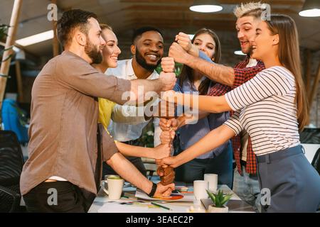 Team Members Engaging in a Collaborative Hands On Activity in a Modern Workspace Stock Photo