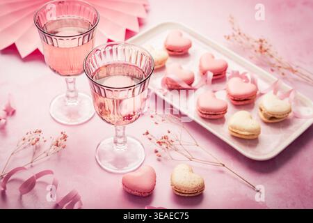 Happy Mothers Day - sweet macarons and glass of rose sparkling wine with flowers in pink tone Stock Photo
