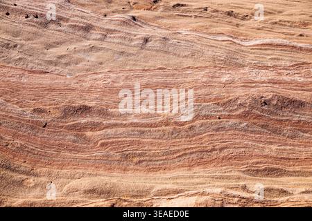 Layered sandstone surface showing natural sediment lines and erosion patterns across dry rocky ground in an arid desert environment. Stock Photo