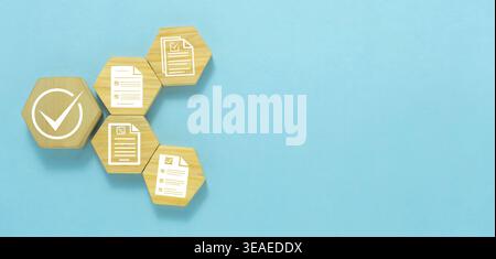 Quality Control Checklist and Approval Process Concept with Check Mark Icons and Document Symbol on Wooden Blocks over Blue Background. Stock Photo