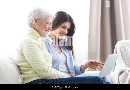 Daughter teaching her elderly mother using laptop Stock Photo