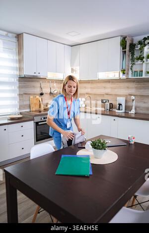 Female Doctor Preparing her Medical Bag in the Kitchen after Finishing Work from Home Stock Photo