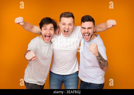 Yes. Cheerful men shouting and celebrating victory Stock Photo