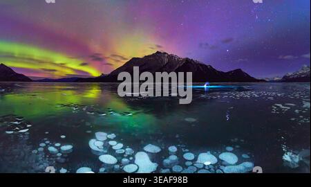 Panorama Frozen Lake Northern Lights and Ice Bubbles Under Winter Night Sky Stock Photo