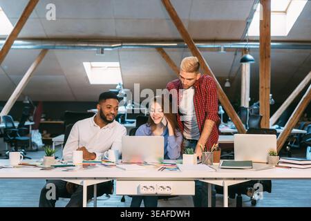 Group Collaborates on Project in Modern Workspace During Daytime Hours Stock Photo