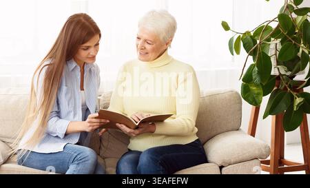 A Young Woman and Her Grandmother Enjoy a Calm Afternoon in a Well Lit Living Room Stock Photo