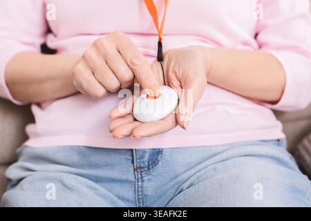 Senior woman hand pressing Alarm Button, closeup Stock Photo