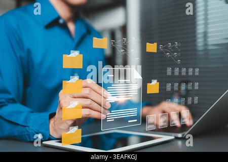 Document Management System Concept. Businessman organizing digital files, folders, and records on connected device. file classification, document work Stock Photo