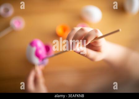 A child holding a brush, painting Easter eggs, acrylic paints, handicrafts, crafts with a child Stock Photo