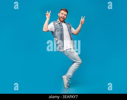 Awesome guy showing peace gesture and standing on tiptoes Stock Photo