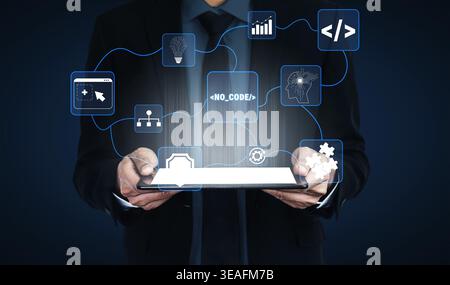 Professional Businessman Holding Tablet with Digital No-Code Development Icons and Technology Symbols in Modern Office Environment Quark. Stock Photo