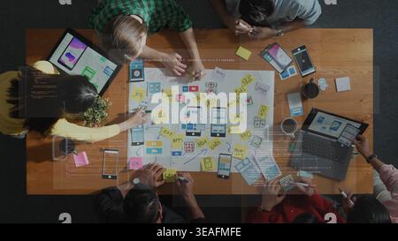 A diverse team collaborates in a modern office, brainstorming ideas and creating wireframes for user interfaces, showcasing creativity and teamwork. R Stock Photo