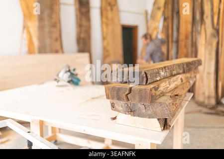Wood slabs stacked on workbench in workshop Stock Photo