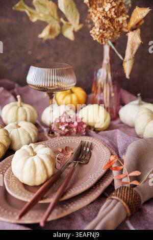 Fall-inspired dining table with pumpkins and elegant tableware Stock Photo