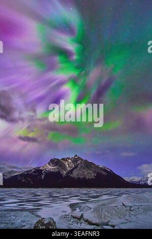 Northern Lights Over Frozen Lake and Mountain in Winter Night Landscape Stock Photo