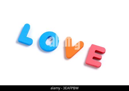 Perspective view word LOVE spelled with multi colored 3D foam letters on light gray background Stock Photo