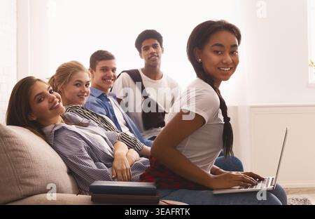 Friends Collaborating on a Project While Relaxing in a Bright Living Room Stock Photo